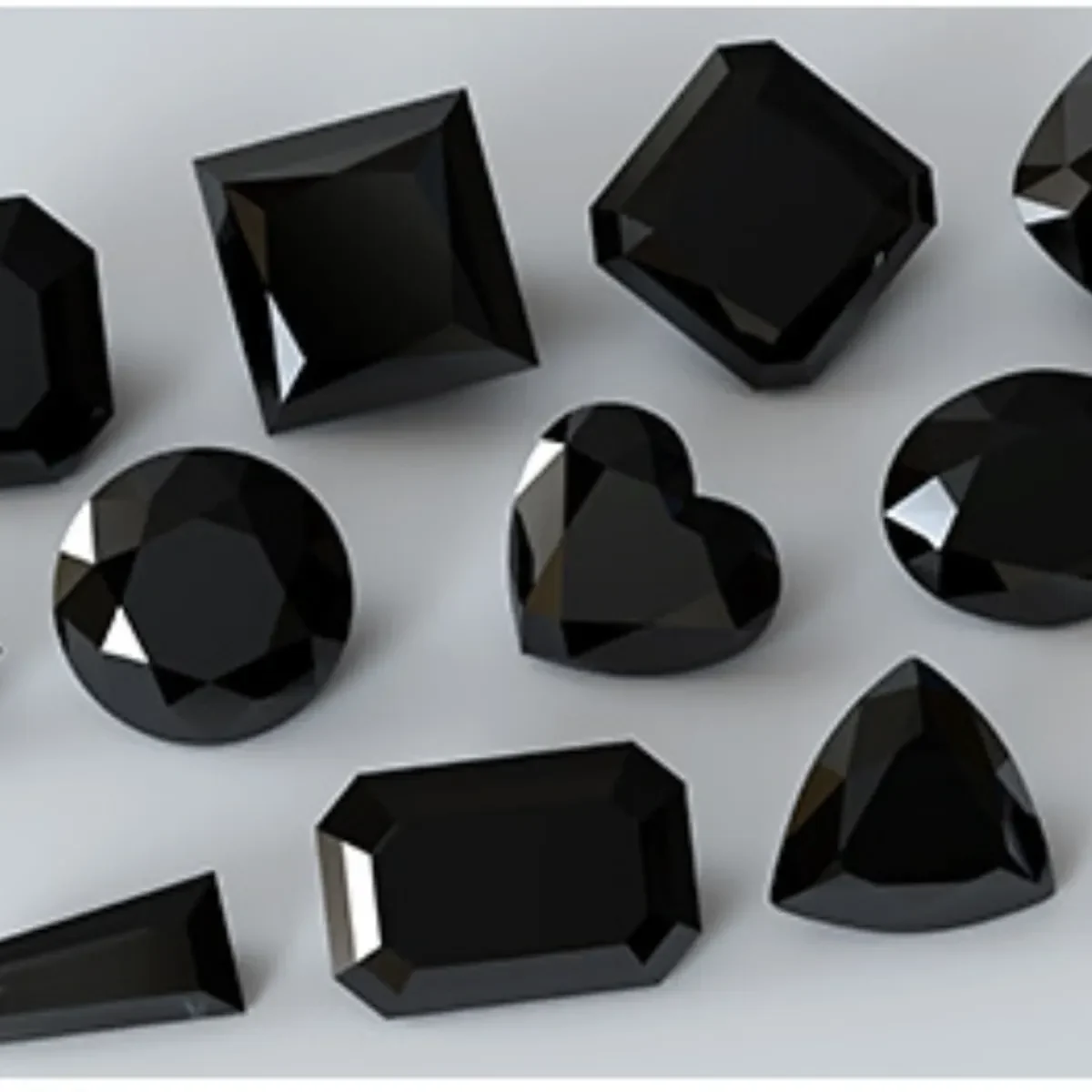 A group of polished black diamonds arranged on a pale surface.